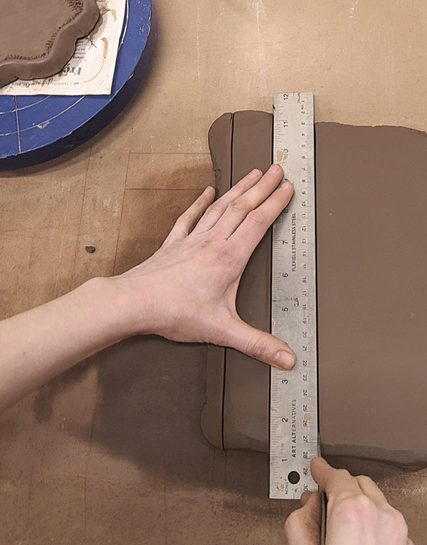 6 Roll out another slab and, using a cork-backed metal ruler to avoid sticking to the slab, cut strips to build up the basket wall.