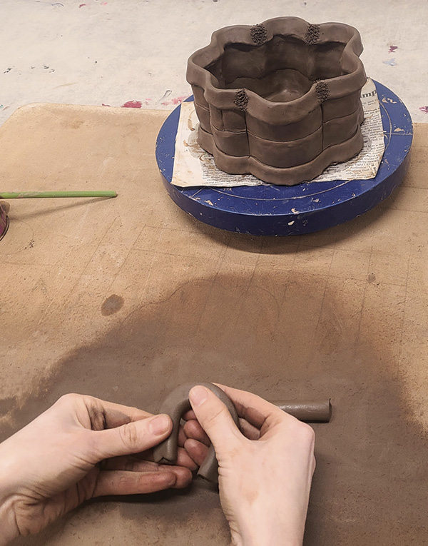 11 Roll ½-in. (1.3-cm)-thick coils, cut them to 4–5 in. (10.1 to 12.7 cm), and pinch them into two horseshoe-shaped handles.