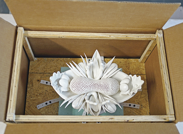 6 Place the wooden scaffold with secured ceramic piece into the inner cardboard box.