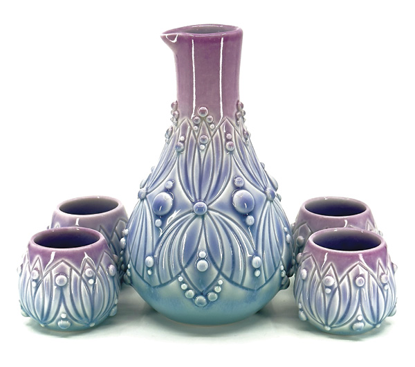 1 Ali Schorman's Sake set, varied dimensions, slip-cast, hand-carved, and slip-trailed porcelain, fired to cone 6, 2026.
