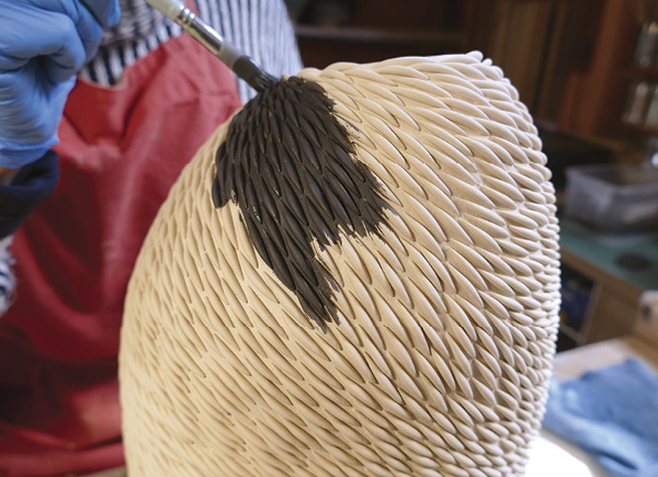 23 Use a brush to apply black engobe.
