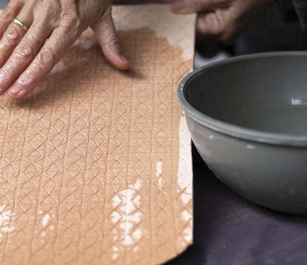 2 Dampen the surface of the embossing tile with water.