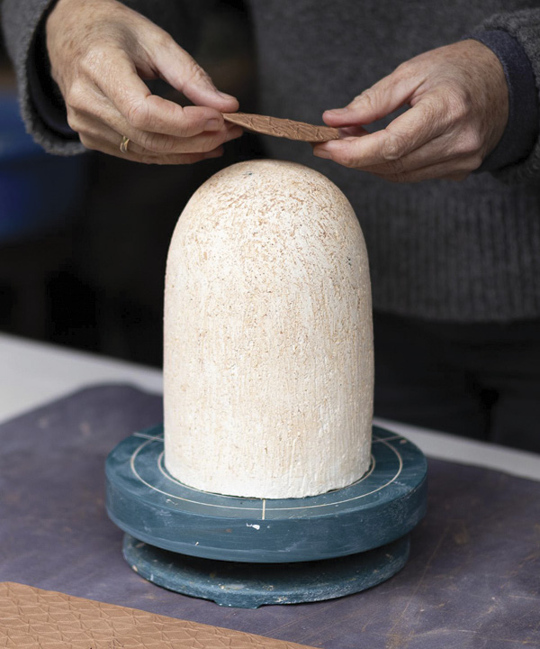 15 Place the circular slab on top of the bisque mold.
