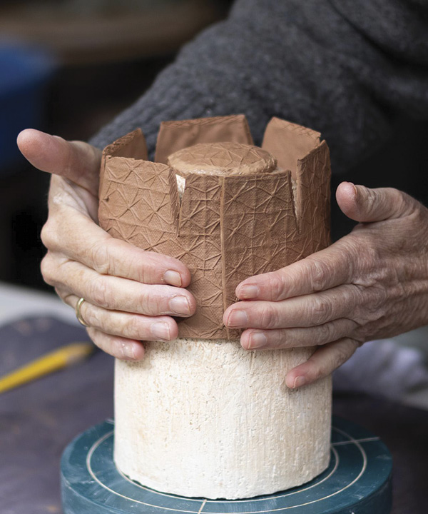 16 Wrap the rectangular slab around the bisque mold, overlap the two ends, and gently push together to join, leaving the seam visible.