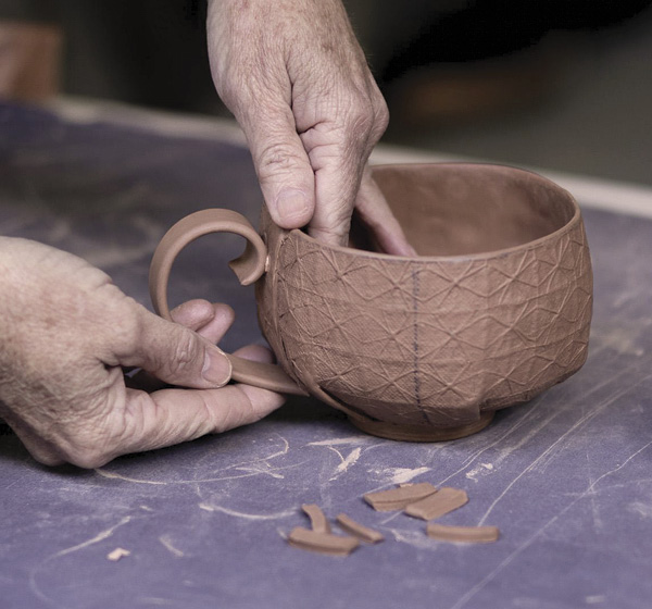 22 Score and apply slip to the corresponding spots on the cup, and, while supporting the wall from the inside, attach the handle.