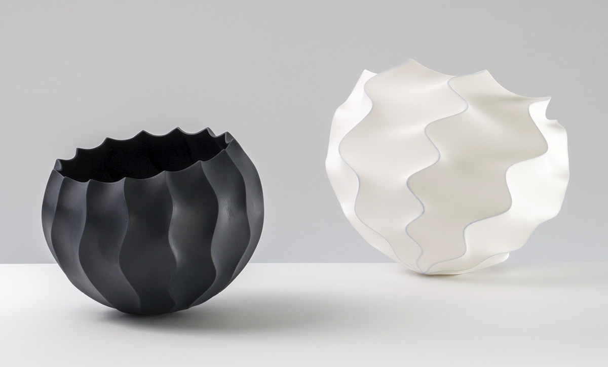 8 Waveform Series Objects (#1311 and #1295), to 9 in. (23 cm) in diameter, slip-cast unglazed black porcelain, unglazed porcelain, soluble metal salts (cobalt), fired to 2167°F (1186°C) in oxidation, wet sanded, 2022.