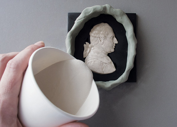 2 Before pouring a plaster mold, brush on a light coating of oil to act as a separator and run a fence of clay around the figure.