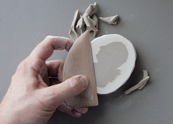 5 Level the clay with a wooden rib, working slowly to avoid tearing the impression.