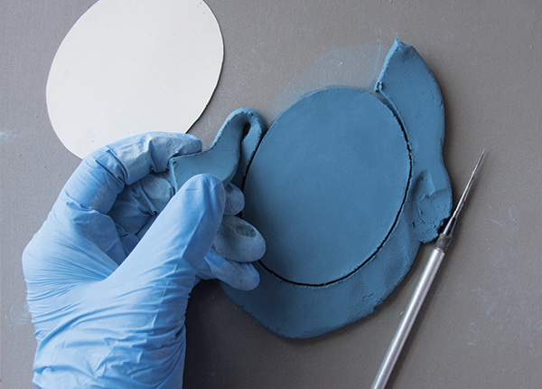 8 Use a paper template and needle tool to cut out the background shape.