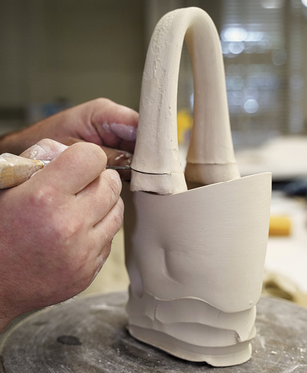 10 Pull a handle thinner in the middle and thick at both ends. Arch it to the correct shape and let it set up. Place it on the basket to test the fit and cut both ends to the desired height.