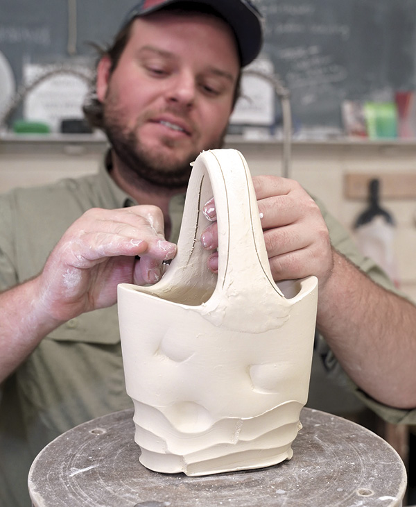 12 Using a fettling knife, cut out the profile for the finished handle. The goal is a flowing handle with varying thickness that grows from the form.