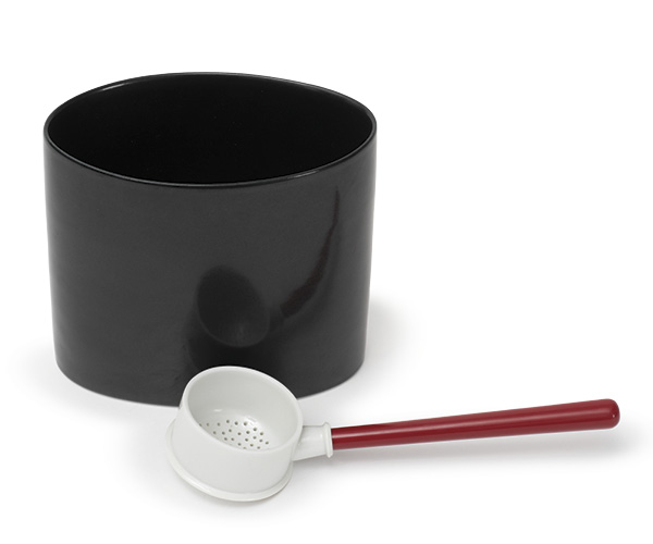 5 Prue Venables’ black oval dish and white sieve with red-lacquer handle, to 7.8 in. (20 cm) in length, hand-thrown and altered Limoges porcelain, black glaze, clear glaze, fired in reduction to 2408°F (1320°C), turned wooden handle, handpainted Chinese red lacquer, 2021. Photo: Ian Hill.