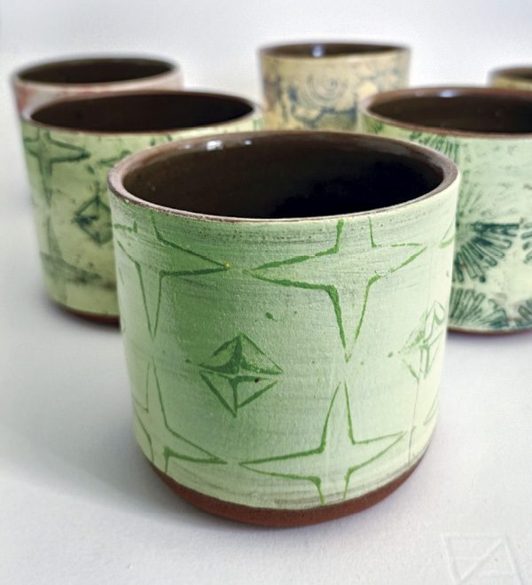 2 Maya McNicoll’s cups, 3.5 in. (9 cm) in height, Mac’s Mud Brick Red clay, underglaze with Darvan 7, Vaughan Smith’s Slip with Oriental Green stain, fired in oxidation to cone 5, 2024.