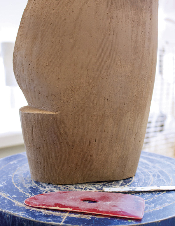10 Finish refining the shape with a saw blade. Use a rubber rib to soften the texture.