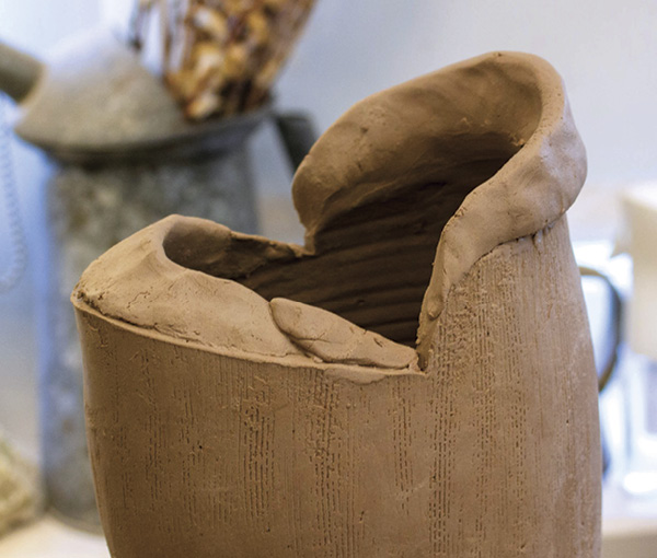 14 Slip and score the rim, and add a tapered coil to the front and back of the pitcher.