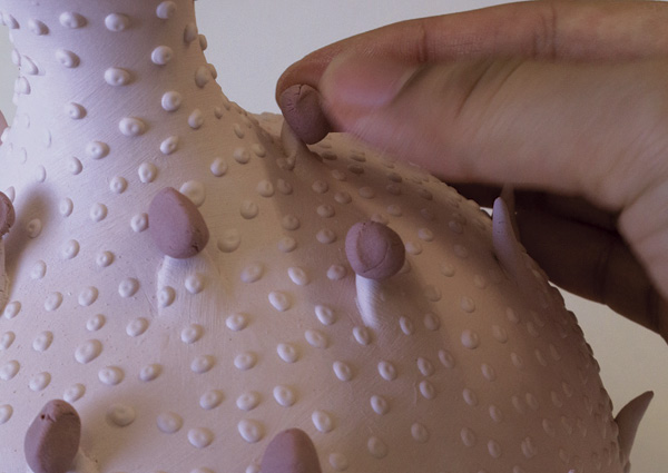 3 Placing gloop glaze on the tip of the bisqued vessel’s spikes.