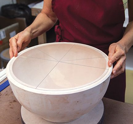 3 Use a circular dividing tool to mark the edge of the mold with guidelines for cutting the slab sections.