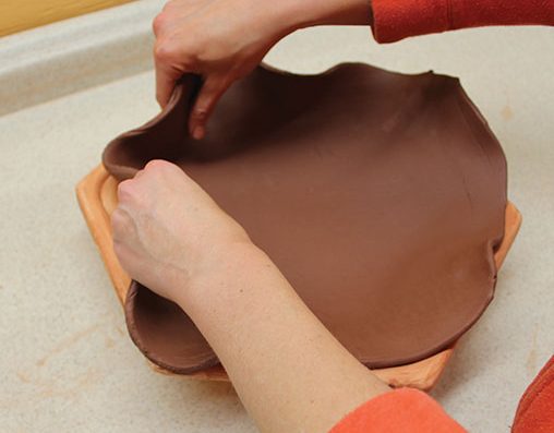 4 Drape a slab over the mold and gently fit it into the space.