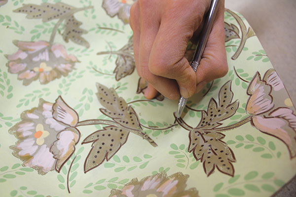 14 Add filler motifs to the background. Carve through the wax, underglaze and slip layers to define the outlines of the foreground.