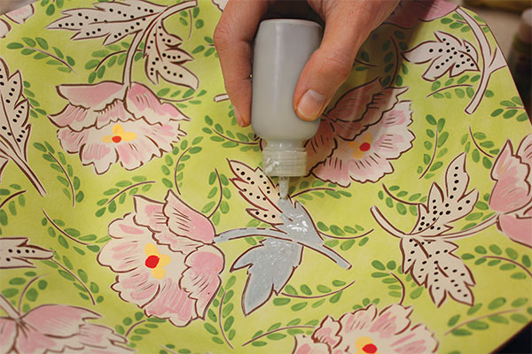 16 Once the bisque plate is dry, touch up any bare spots from the sanding process, then add glaze to areas of the motifs