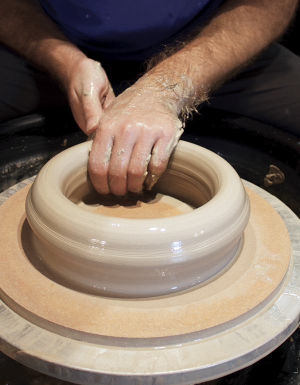 1 Center four pounds (1.8 kg) of clay on a bat or wheel head and open it into a ring.