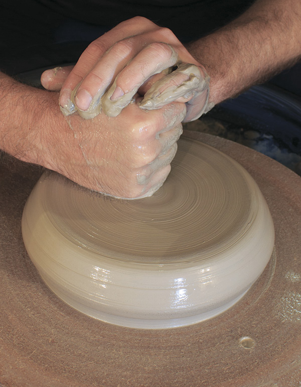 5 Center a six-pound (2.7-kg) ball of clay low and wide on a bat.