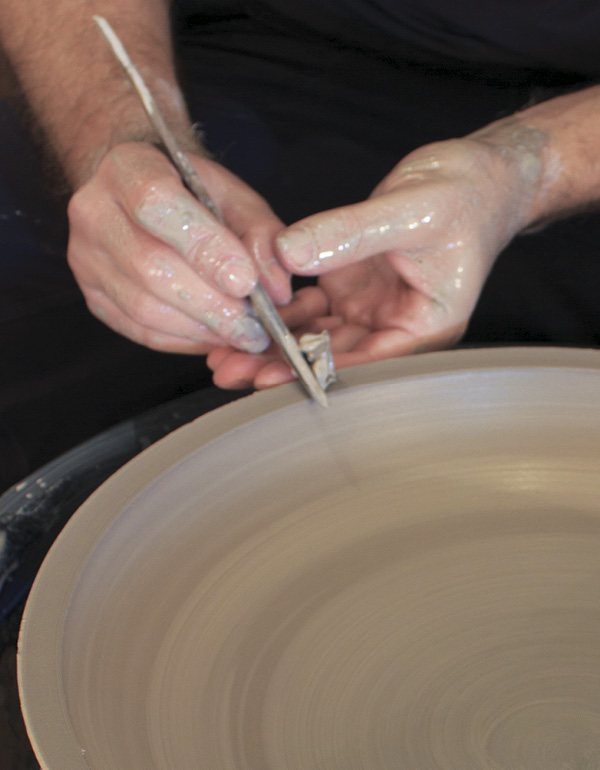 10 Support the rim with your finger while shaping the lip with a wooden knife.