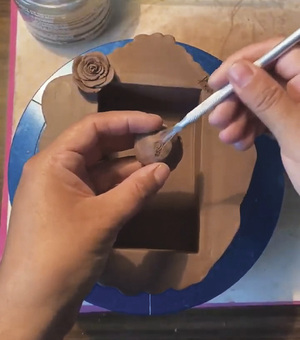 4 To complete the box, sculpt flower and heart details. Once they are leather hard, attach them.
