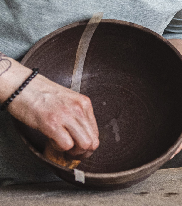 1 Cut and apply a newsprint stencil to a leather-hard clay form using a slightly damp sponge.