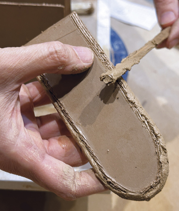 4 After scoring the beveled edges, smear the thick mortar slip on top of the scored areas of one slab. I use a chopstick.