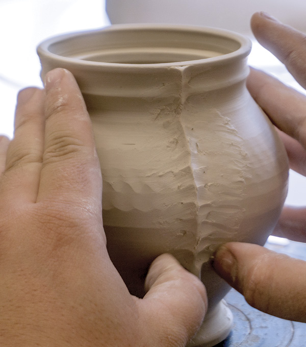 2 Slip, score, and attach a soft coil from the rim to the foot at each mark. Refine by pinching and blending the coil.