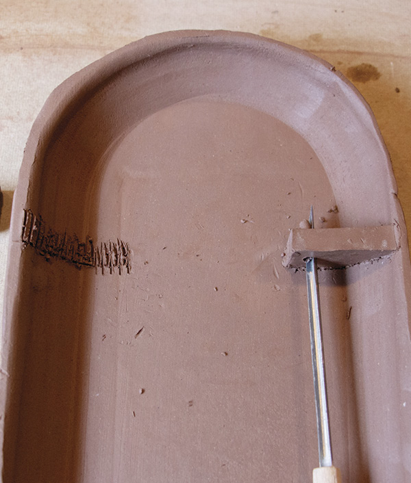 12 Attach clay wedges to the sconce back and punch holes into each piece.