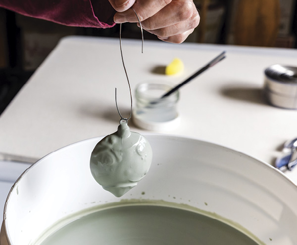 15 Using a length of wire threaded through the nichrome hook, dip the ornament into glaze.