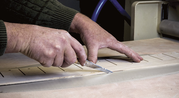 3 Lay the template onto the rolled clay slab and cut around it using a fettling knife.