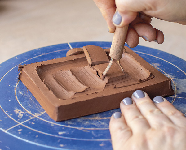 1 Use a trimming tool to carve out clay from the center of the slab.