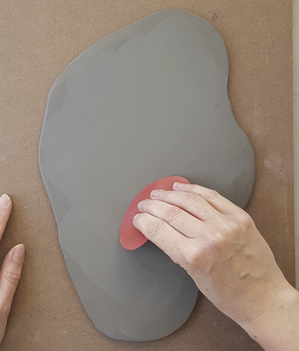 5 Smooth the surface of the slab with a flexible, kidney-shaped rib to remove texture and compress slab.