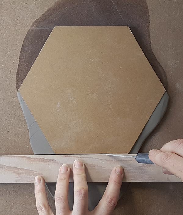 6 Spray the slab lightly with water and place template on top. Use a straightedge and a sharp knife to cut out tile.