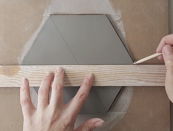 7 Lay a straight edge from point to point and draw a faint line to visually divide the tile in half. Next, use the straight edge on two alternate points and draw another line to further divide.