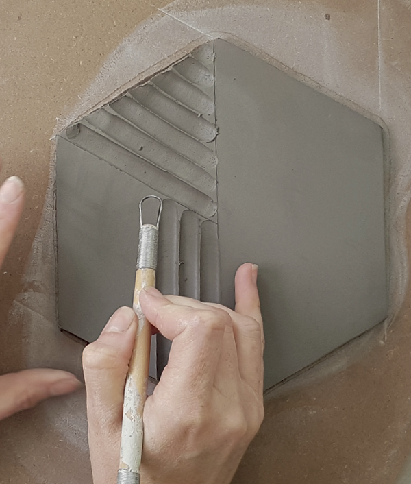 10 Rotate your tile to carve similar lines in a contrasting direction to the first carved section.