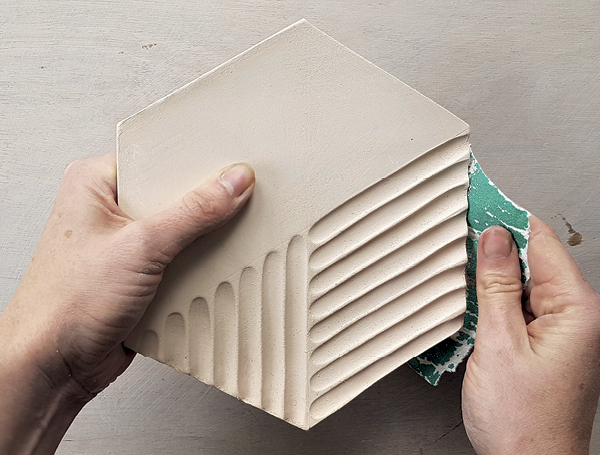13 Once the tile has been bisque fired, gently sand the edges to remove burrs. Next, apply one glaze to the uncarved surfaces and a contrasting glaze to the carved sections before firing.