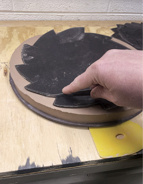 1 Trace a template made from roofing paper onto a slab, then cut it out.