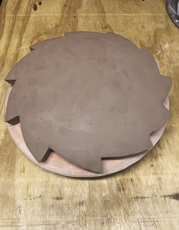 2 Drape the cut-out shape over a bisque-fired hump form to slightly firm up.