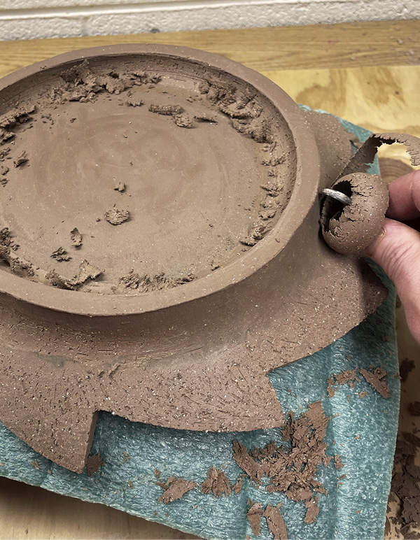 12 Flip the plate back onto the foam-covered bisque mold, then refine the base.