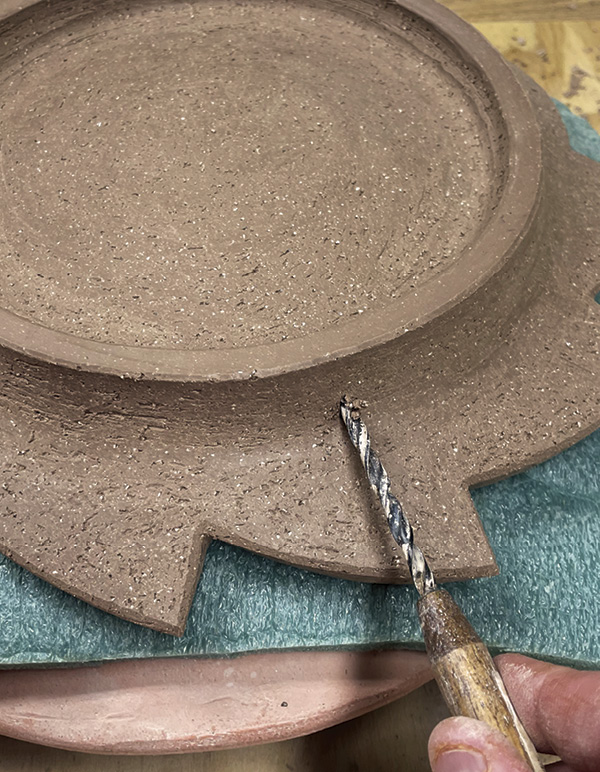 13 Use a drill bit to create holes for the hanging hardware added post firing.