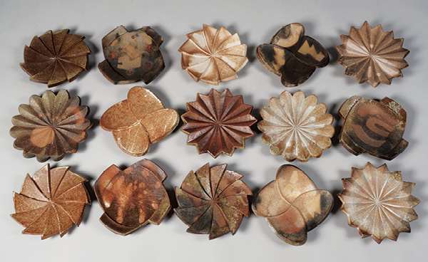 Will Dickert's carved plates, various designs, approximately 10½ in. (26.7 cm) in diameter each, handbuilt stoneware, slips, glazes, fired to cone 10–11 in a wood kiln, 2023–24. Photo: Tim Barnwell.
