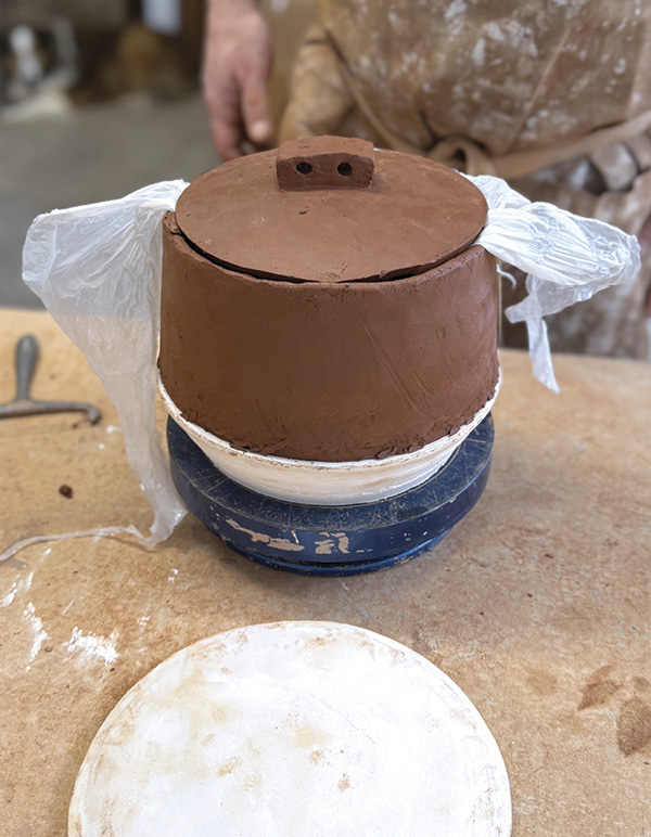 14 Place a plastic bag over the rim to make the lid easier to remove while shaping.
