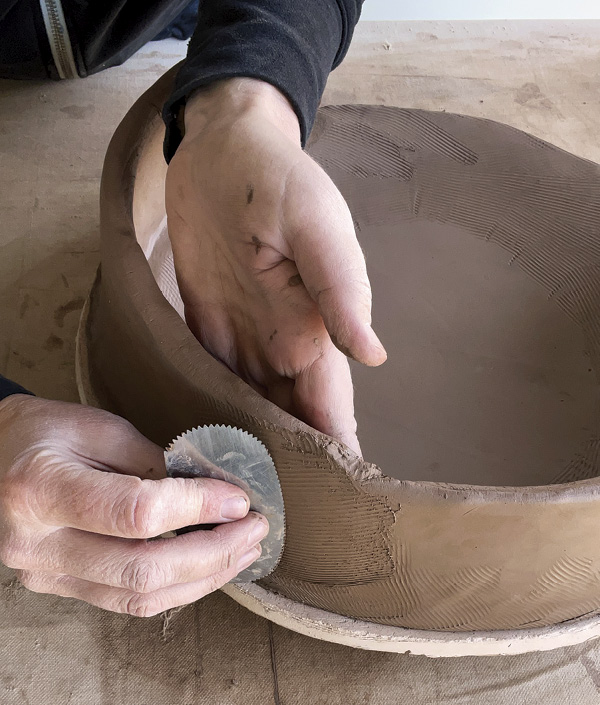 7 Overlap each wall as you add sections, score, slip, compress, and then even out the wall thickness with a serrated rib.
