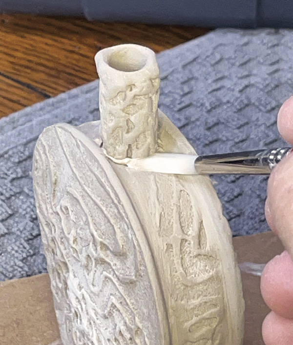 18 Score the opening and the clay neck. Add slip to both parts and join both parts. Clean the joint with a soft brush.