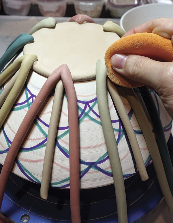 6 Work your way around the form adding the colored coils and smoothing seams.