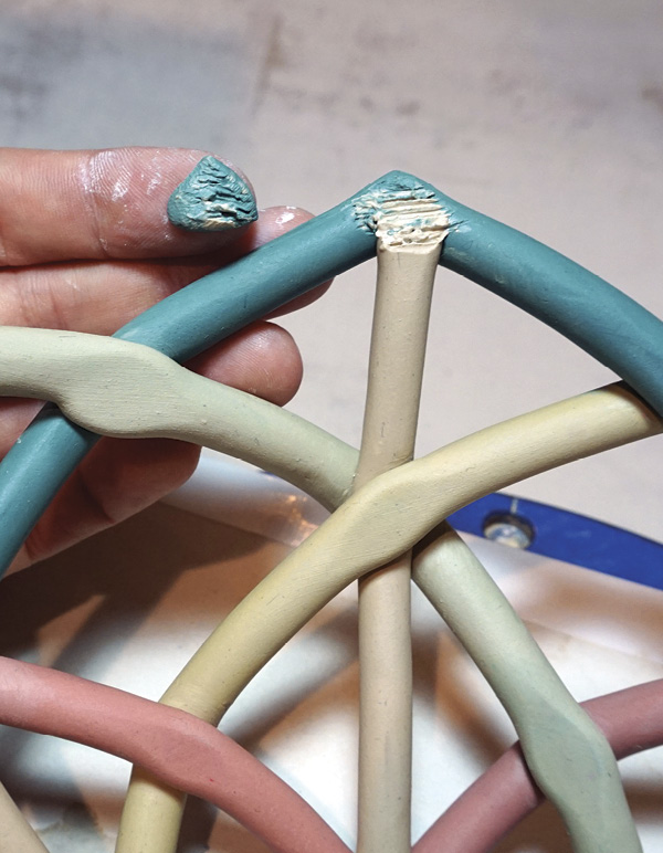 13 Cut the end of the upright coil at an angle and then attach clay to cover it.